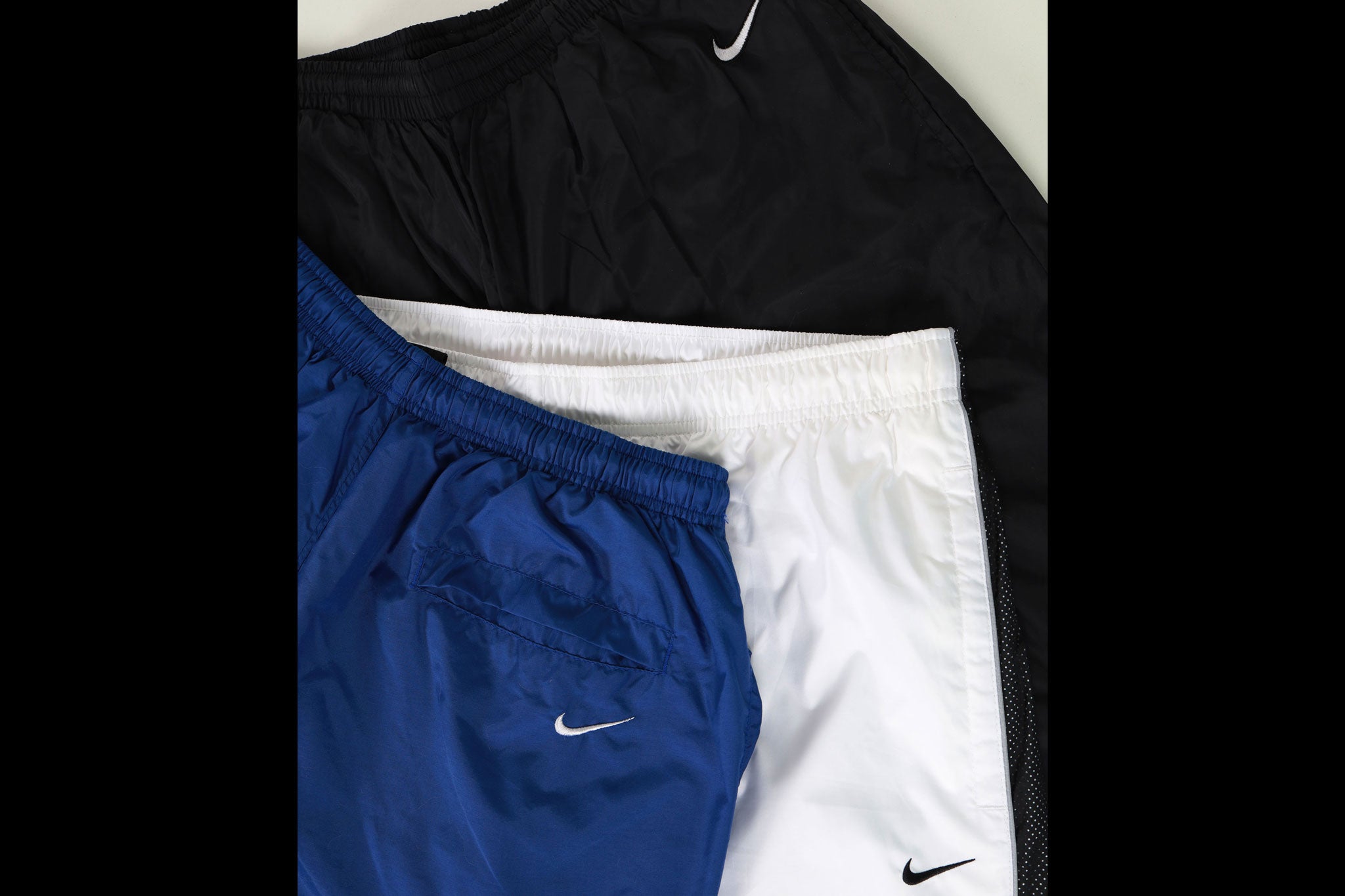 flat lay nike tracksuits - white, blue and black